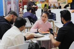 Un représentant d'une entreprise vietnamienne présente ses produits à l'ITB Berlin 2026. (Photo : VNA)