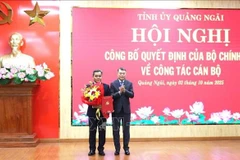 Le Minh Hung, membre du Bureau politique, secrétaire du Comité central du Parti et président de sa Commission d'organisation (droite) félicite Ho Van Nien. Photo ; VNA