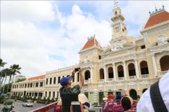 Des visiteurs internationaux explorent le centre-ville d'Hô Chi Minh-Ville à bord d'un bus à impériale. Photo : VNA