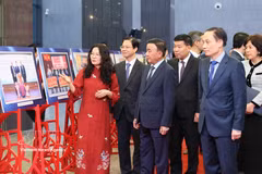Trân Câm Tu, membre du Bureau politique, secrétaire du Comité central du Parti et permanent du Secrétariat du Comité central du Parti, avec des délégués lors de la visite de l’exposition de photos mettant en lumière les activités de relations extérieures populaires en 2025. Photo : VNA