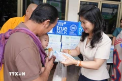 Mme Vu Thi Dung, épouse de l'ambassadeur du Vietnam au Laos, offre un cadeau à un bébé à l'hôpital pédiatrique du Laos. Photo : VNA