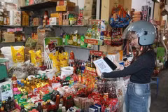 Des clients effectuent un paiement par virement en scannant un QR code au marché de Ky Ba. Photo: VNA