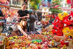 Les touristes étrangers aiment en savoir davantage sur les jouets traditionnels vietnamiens de la Fête de la mi-automne.. Photo : VNA