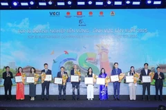 Le vice-Premier ministre Ho Duc Phoc et Ho Sy Hung, président de la hambre de Commerce et d'Industrie du Vietnam honorent dé représentants des 100 entreprises les plus durables du pays. Photo : VNA