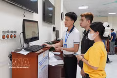 Un agent du Centre de services administratifs publics du quartier de Vinh Yen guide un citoyen dans les démarches d’enregistrement de mariage sur le portail national de services publics en ligne. Photo : VNA