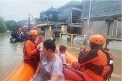 Rescuers from Indonesia's National Search and Rescue Agency evacuate residents from a flooded home in Denpasar, Bali. (Photo: AP)