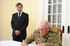 Le lieutenant-général Alvaro Lopez Miera, ministre des Forces armées révolutionnaires de Cuba, écrit dans le registre de condoléances de l'ambassade du Vietnam à Cuba. (Photo : VNA)