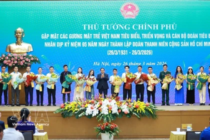 Le Premier ministre Pham Minh Chinh offre des fleurs de félicitations aux jeunes Vietnamiens exemplaires. Photo : VNA