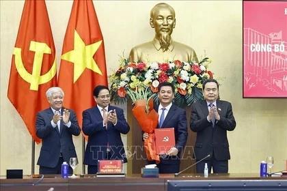 Le président de l’Assemblée nationale, Tran Thanh Man, a remis la décision, et le Premier ministre Pham Minh Chinh a offert des fleurs pour féliciter Nguyen Hong Dien. Photo: VNA