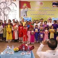 Les délégués posent avec les enfants lors de la cérémonie d’inauguration de la bibliothèque de livres en vietnamien à Udon Thani, en Thaïlande. Photo : VNA