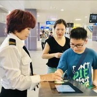 Une employée de Hanoi Metro guide un jeune usager du métro de Hanoi. Photo : VNA