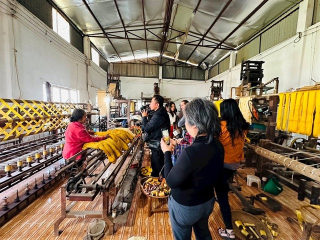 L'artisane Phan Thi Thuân (à gauche) parle avec ses visiteurs de la soie de Phung Xa et de sa soie de lotus. Photo: VNS artisane-phan-thi-thuan.jpg