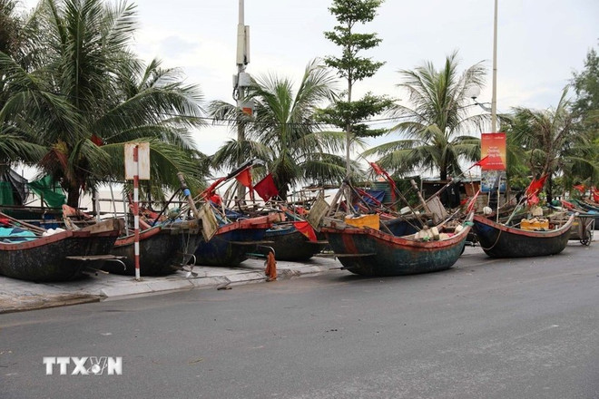 Les habitants du quartier de Sam Son, dans la province de Thanh Hoa, déplacent leurs bateaux sur la route pour se protéger de la tempête. Photo: VNA thanh-hoa.jpg