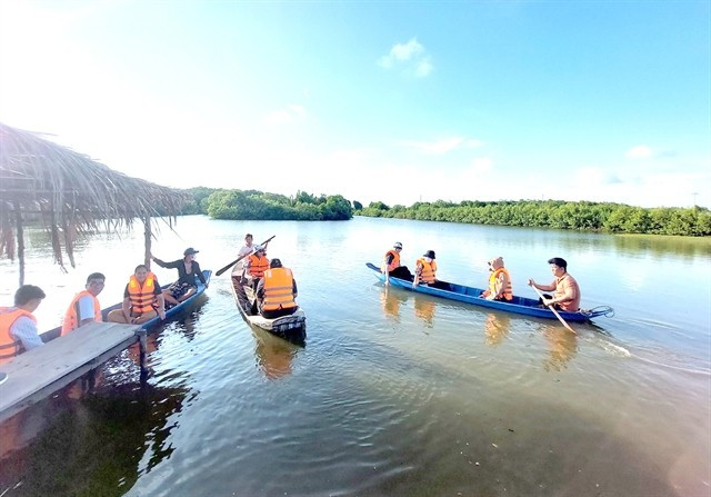 Des visiteurs profitent d’une promenade en barque à travers la mangrove de l’île fluviale de Bao, dans la province de Vinh Long. Photo : VNA promenade-en-barque.jpg