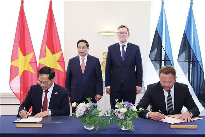 Les deux Premiers ministres ont assisté à la signature et à l’échange d’un protocole d’accord de coopération entre les ministères vietnamien et estonien des Affaires étrangères. Photo : VNA pham-minh-chinh-kristen-michal-signature.jpg
