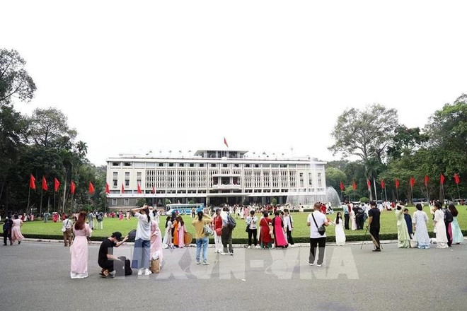 Visiteurs devant le Palais de la Réunification à Hô Chi Minh-Ville. Photo: VNA palais-de-la-reunification.jpg