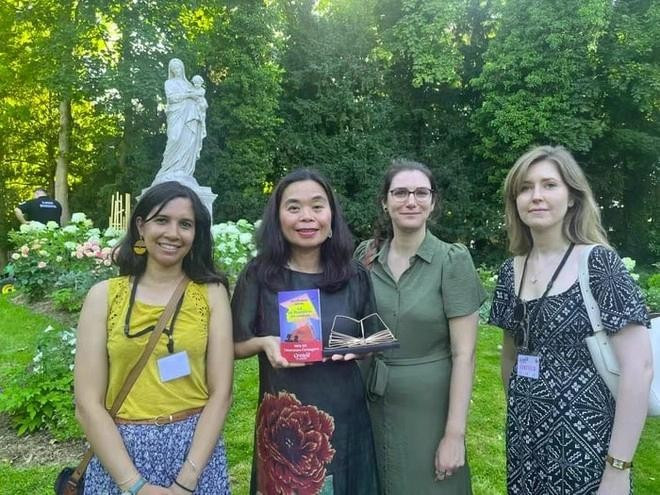 Nguyên Phan Quê Mai (deuxième à partir de la gauche) montre son prix littéraire français. Photo : anninhthudo.vn que-mai-anninhthudo.jpg