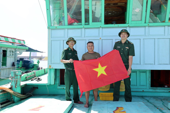 Le poste de garde-frontière de Son Trà (commandement des garde-frontières de la ville de Dà Nang) offre un drapeau national à un bateau de pêche. Photo : VNA son-tra-bateaux-de-peche.jpg