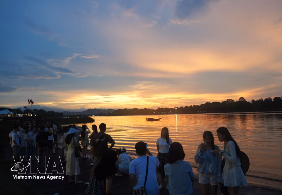 Des touristes profitent des berges de la rivière des Parfums, à Huê, pour admirer le coucher du soleil à l’occasion de la Fête nationale, le 2 septembre.Photo : VNA