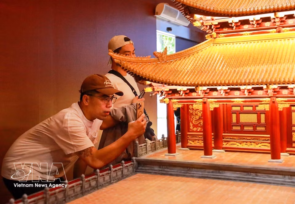 Des visiteurs découvrent la maquette du palais Kinh Thiên. Photo : VNA