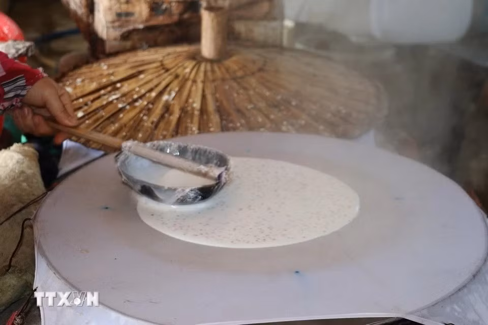 L’ouvrier fait de l’étalage rapide de la farine afin de garantir que le papier ait la bonne épaisseur. Photo: VNA