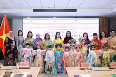 Des délégués et des enfants participent à un défilé de l'"áo dài". Photo : VNA
