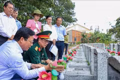 Le vice-président du Comité populaire de la province de Tay Ninh, Pham Tan Hoa (gauche, assisse), accompagné d'une délégation, examine les informations sur les tombes des martyrs non identifiés au cimetière des martyrs d'An Tinh, quartier d'An Tinh, province de Tay Ninh. Photo : VNA