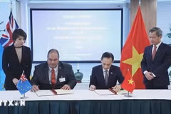 Le Hoai Trung (droite), ministre vietnamien par intérim des Affaires étrangères et Paulson Panapa, ministre des Affaires étrangères, du Travail et du Commerce de Tuvalu, signent un communiqué conjoint sur l’établissement des relations diplomatiques entre la République socialiste du Vietnam et Tuvalu. Photo : VNA