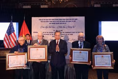 Le secrétaire général et président To Lam (centre) remet à titre posthume l'Ordre de l'Amitié à ses amis américains. Photo : VNA