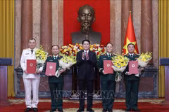 Le président Luong Cuong remet les décisions de promotion au grade de général de corps d’armée à quatre officiers supérieurs de l’Armée et de la Police populaires du Vietnam. Photo : VNA