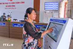 Une femme venue pour effectuer les démarches administratives au Centre de services de l'administration publique de la commune de Xuan Hong, à Ninh Binh. Photo : VNA