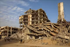 Des habitants marchent au milieu des décombres d'immeubles détruits par le conflit à Gaza. Photo : Xinhua/VNA