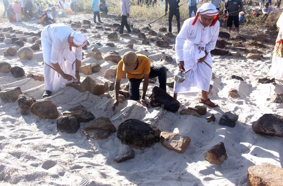 Dans le cadre de leurs rituels, les clans Cham effectuent des gestes symboliques tels que le balayage du sable et l'aspersion d'eau, visant à purifier les tombes et à honorer la mémoire de leurs ancêtres. Photo : VNA