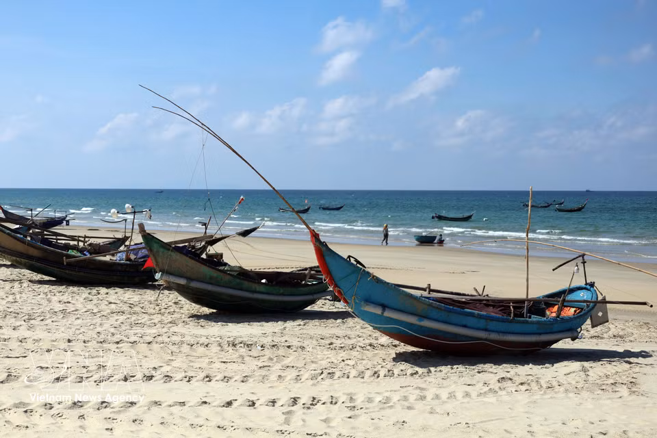 De petites embarcations de pêcheurs reposent sur le sable fin et blanc après leur retour de mer, offrant une image paisible et authentique de la vie quotidienne sur le littoral.