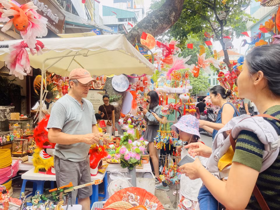 Les enfants sont accompagnés par leurs parents dans la rue Hàng Ma (quartier de Hoàn Kiêm, à Hanoï) pour choisir des jouets de la Fête de la mi-automne. Photo : VNA