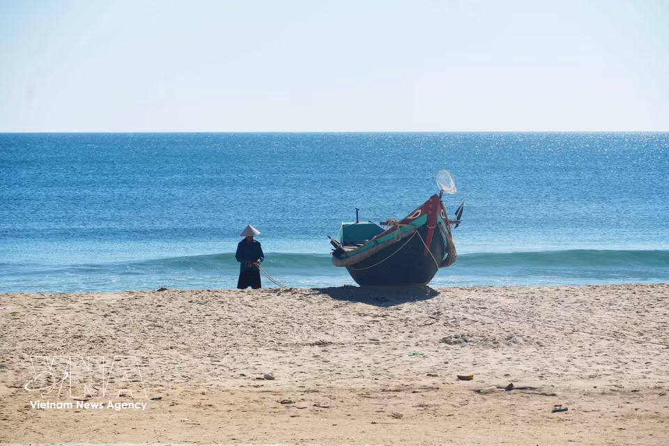 Des pêcheurs exercent leur métier dans un cadre paisible au bord de la plage de la commune de Ben Hai, dans la province de Quang Tri. Photo : VNA