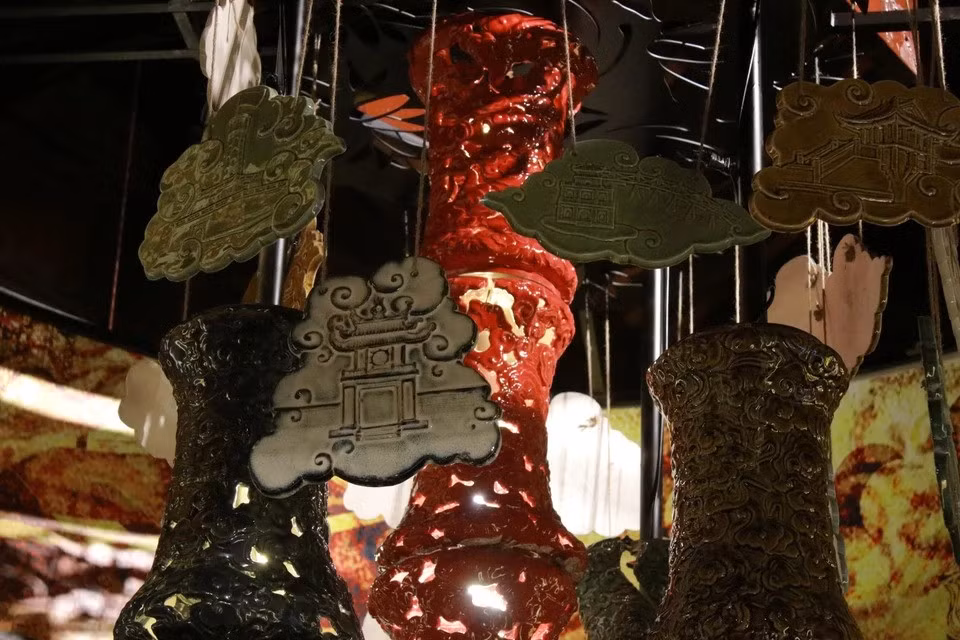 Cette imposante lampe en bronze est une véritable ode aux métiers d'art traditionnels. Sa surface est ornée de reliefs minutieux représentant une multitude de scènes de la vie quotidienne des artisans de la fonderie, de la forge, de l'orfèvrerie, de la broderie, de la fonte du bronze, de la fabrication de papier votif, de la sculpture de sceaux... Photo : VNA