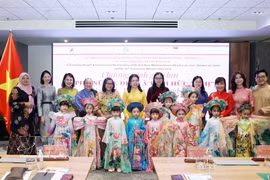Des délégués et des enfants participent à un défilé de l'"áo dài". Photo : VNA