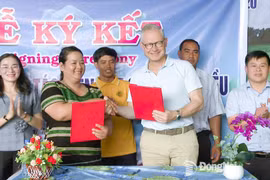 Mme Thi Khui, cheffe de la coopérative agricole d’anacarde biologique de Trang Co – Bu Lach, signe un accord de coopération pour l'achat de noix de cajou avec un représentant de la sarl Intersnack Vietnam. Photo : Journal Dong Nai