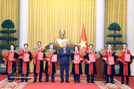 Le secrétaire général du Parti et président, To Lam, remt les décisions de nomination des juges de la Cour populaire suprême. Photo : VNA