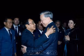 Bounthong Chitmany, permanent du secrétariat et vice-président du Laos, dit au revoir le secrétaire général To Lam et son épouse à l'aéroport international de Wattay, à Vientiane. Photo : VNA