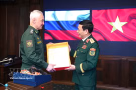 Le vice-Premier ministre et ministre vietnamien de la Défense, le général Phan Van Giang (droite), et le ministre russe de la Défense, Andreï Belooussov échangent des cadeaux commémoratifs. Photo : VNA