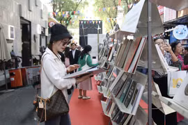 Des passants à une exposition des titres de livres les plus populaires dans la rue des livres de Hô Chi Minh-Ville. Photo : VNA