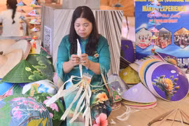 Un artisan du village de Chuong, spécialisé dans la fabrication de chapeaux coniques, fait la démonstration de son savoir-faire au marché créatif «Kết duyên Sáng tạo». Photo : VNA