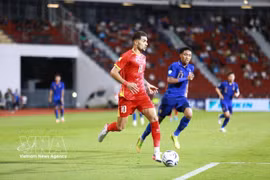 Hoang Hen (numéro 10 – équipe nationale du Vietnam) tente de dribbler un joueur thaïlandais. Photo : VNA