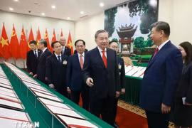 Le secrétaire général du Parti To Lam et le secrétaire général du Parti et président chinois Jinping assistent à la présentation des documents de coopération entre les deux pays. Photo : VNA