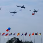 Un vol de formation d’hélicoptères arborant le drapeau national vietnamien effectue une démonstration aérienne lors de la cérémonie d’ouverture de l’Exposition internationale de défense du Vietnam 2024. Photo : VNA