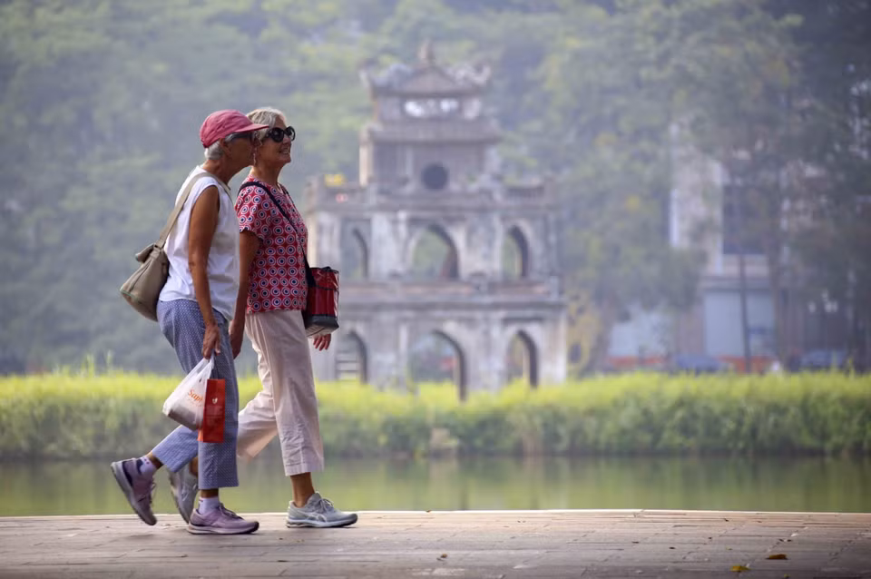 Touristes étrangers se promenant au bord du lac Hoan Kiem. Photo : VNA