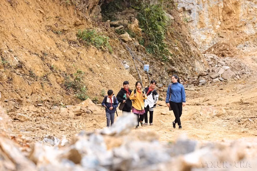 L'enseignante Vu Thi Le de l'école secondaire Pa Vay Su, située dans la commune de Pa Vay Su, district de Xin Man, province de Ha Giang, fait preuve d'un engagement remarquable en accompagnant quotidiennement ses élèves malgré les difficultés de transport. Photo : VNA