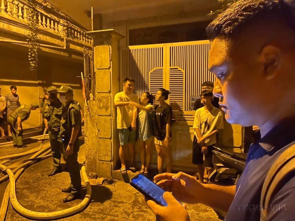 Le journaliste Pham Kien de la VNA travaille sur la scène de l'incendie d'un immeuble d'appartements dans la rue Khuong Ha (à Hanoï). Photo : VNA